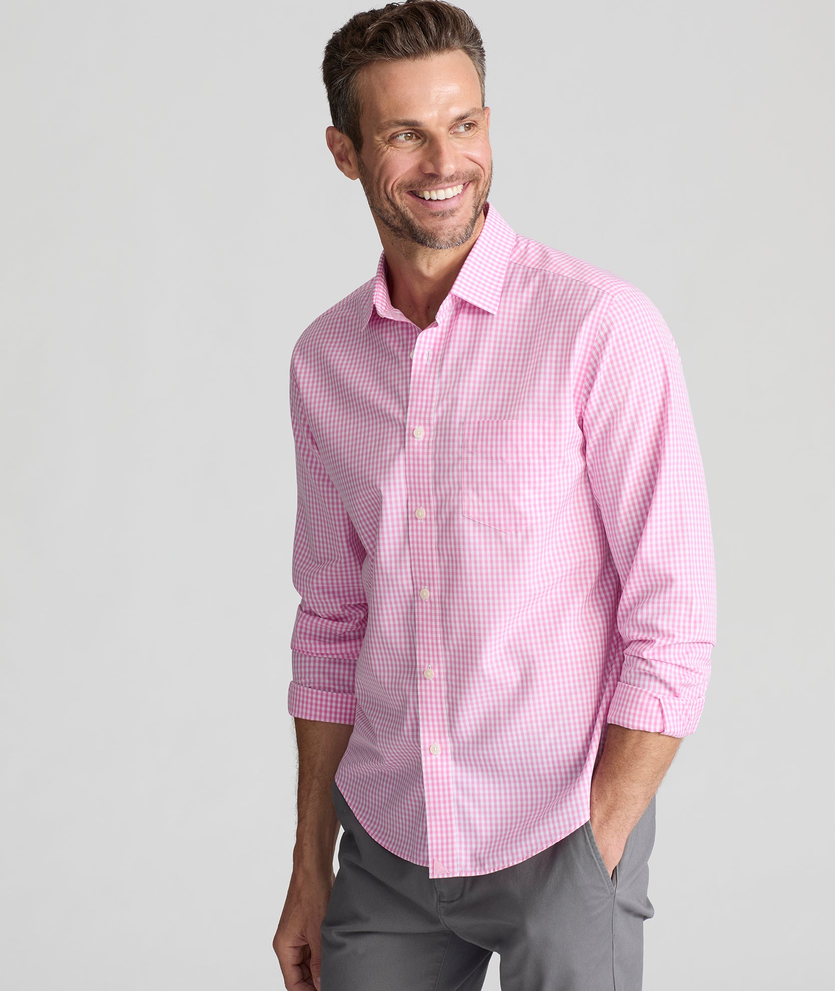 Model is wearing UNTUCKit Barclay wrinkle free shirt in pink gingham.