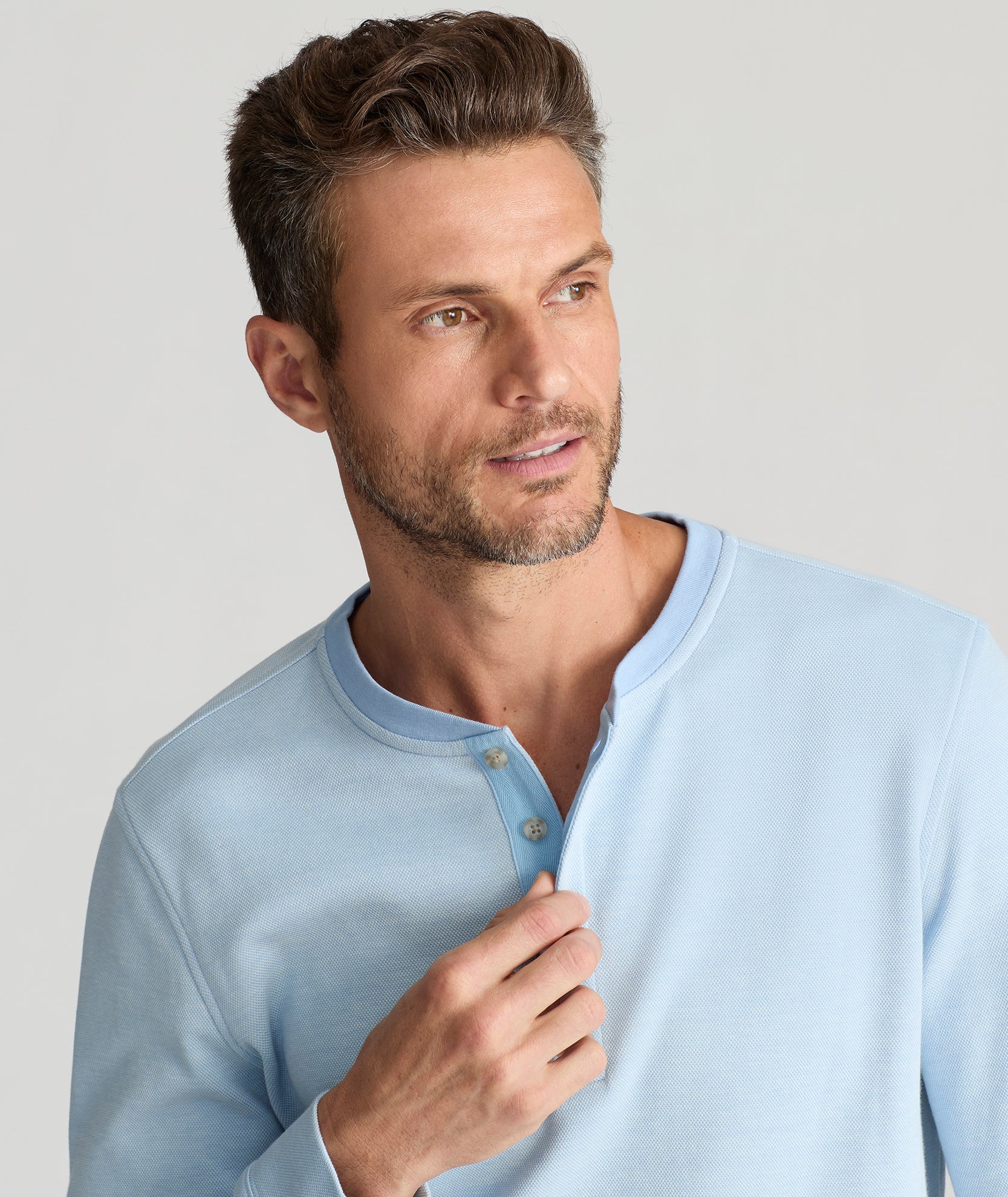 Model is wearing UNTUCKit Cascudo LS Pique Henley in Blue Bell.