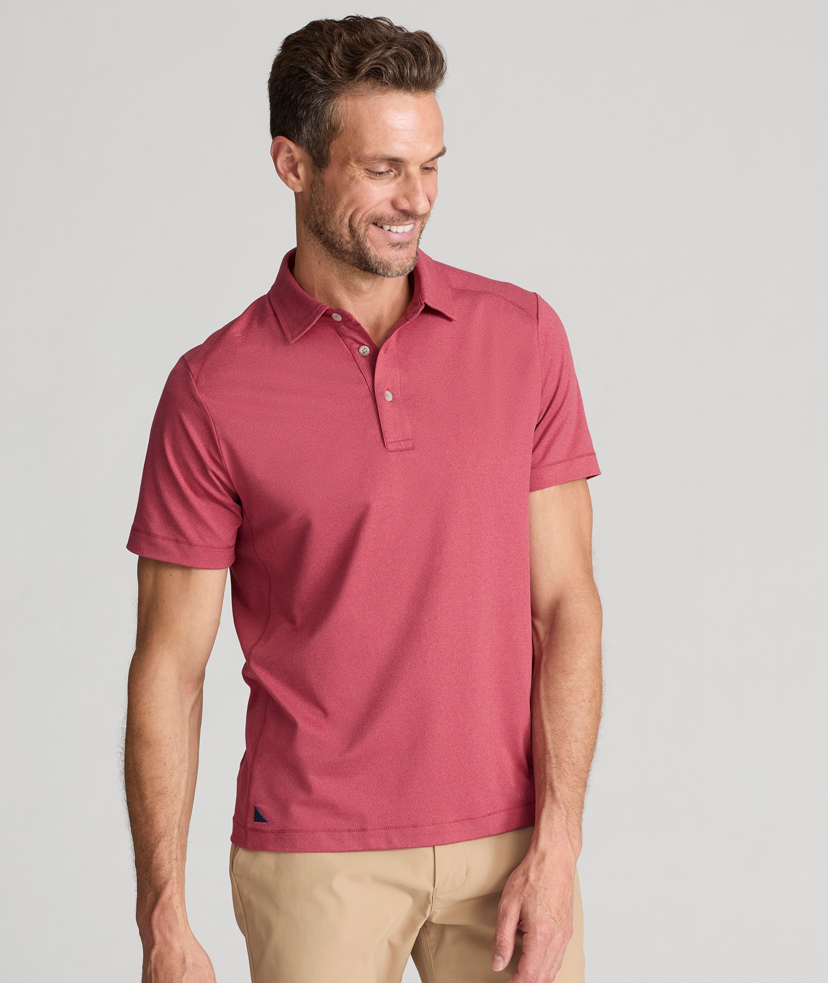 Model wearing a  Performance Polo in faded red.