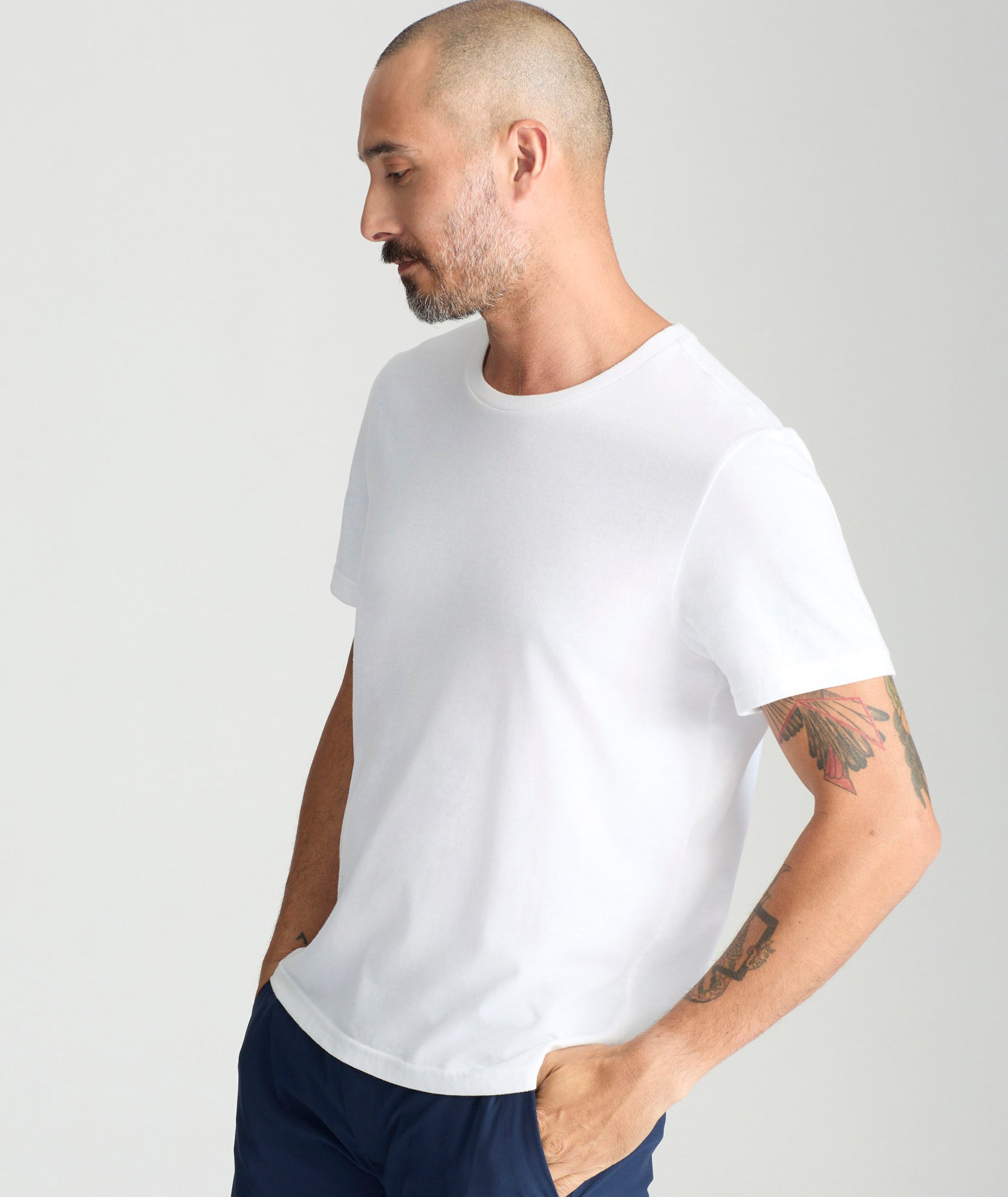 Model is wearing UNTUCKit saxum tee in white. 