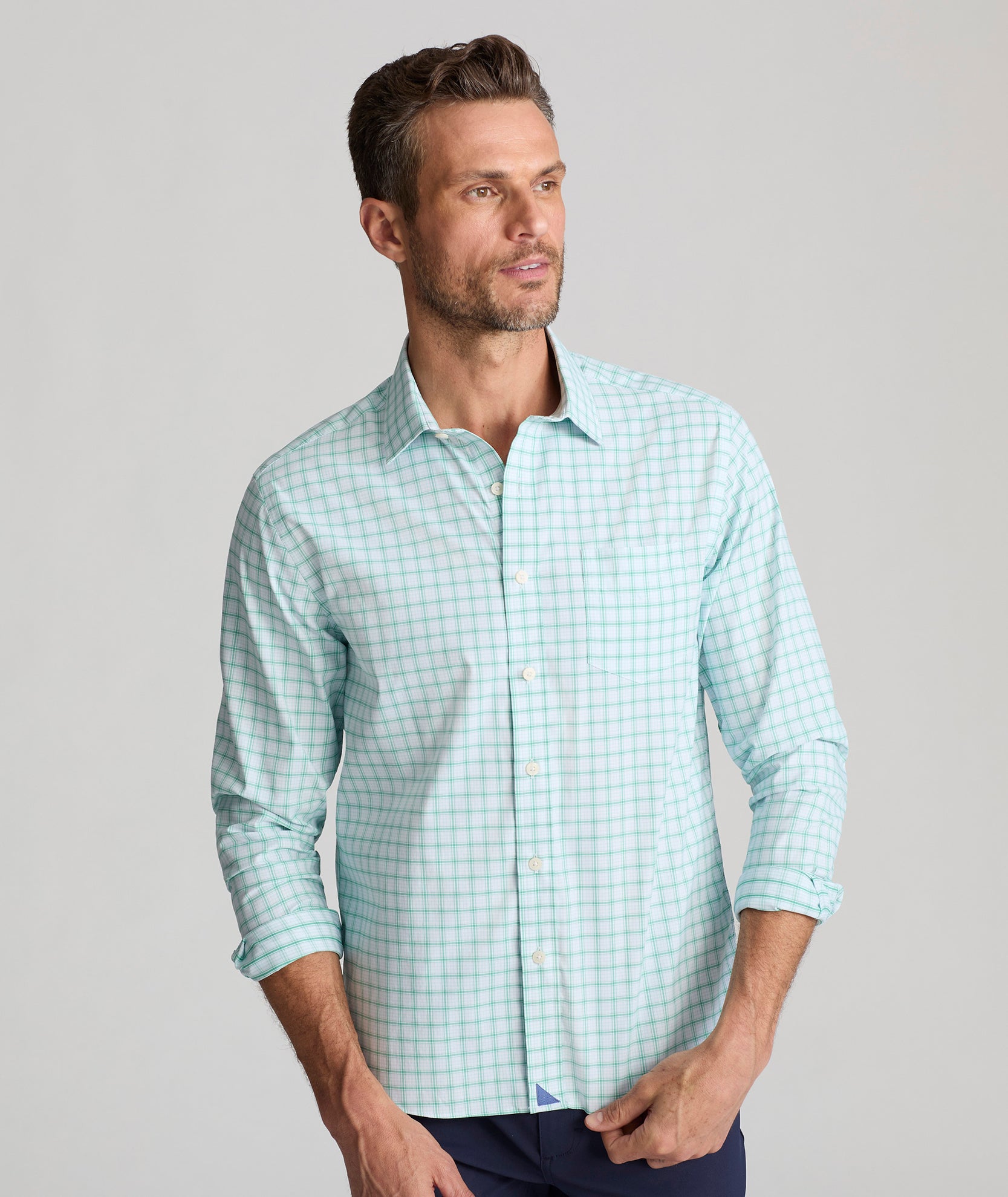 Model is wearing UNTUCKit Wells in light blue and green check. 