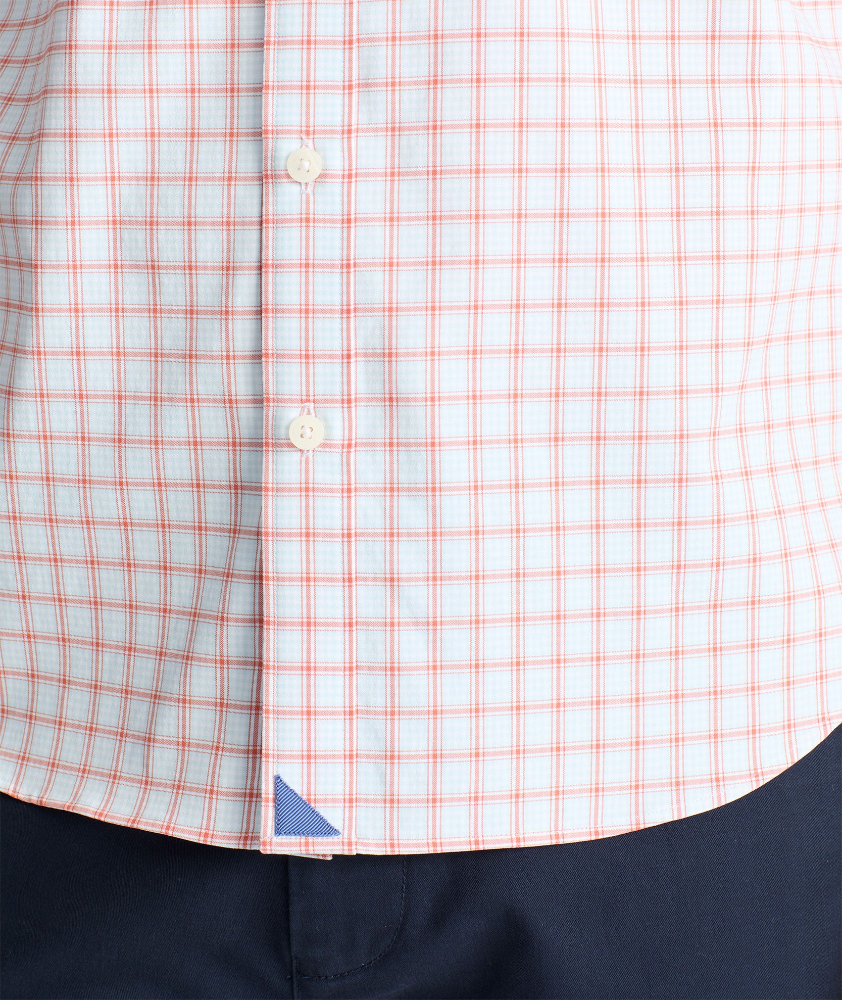 Model is wearing UNTUCKit Wells performance shirt in light blue and orange check. 