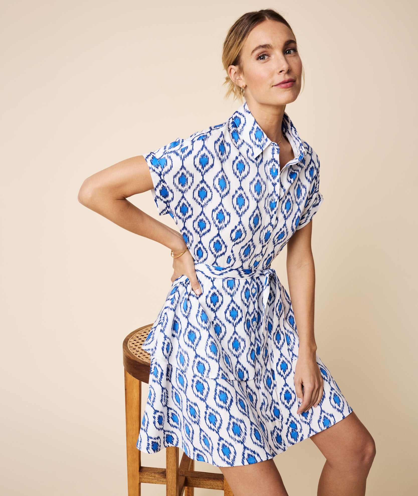 Model is wearing UNTUCKit White and Blue Double Flounce Hem Stretch Cotton Renata Shirtdress.